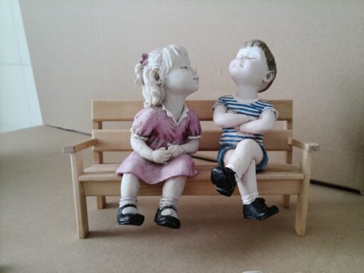 Beeld jongen en meisje zittend op bankje 17cm