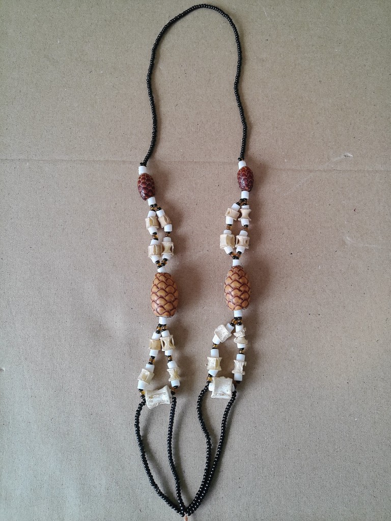 Afrikaanse amulet ketting met dennenappels en bot 34cm